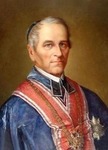 Obraz przedstawia portret mężczyzny w średnim wieku lub nieco starszego, ujętego od pasa w górę, w formalnym stroju ceremonialnym. Postać zwrócona jest delikatnie w lewo, ale patrzy prosto przed siebie, z wyrazem spokoju, powagi i pewności siebie. Wygląd postaci: Mężczyzna ma szlachetne rysy twarzy: wysokie czoło, szerokie kości policzkowe i ostro zarysowaną szczękę. Cera jasna, gładka, bez wyraźnych zmarszczek. Włosy są krótkie, zaczesane gładko do tyłu, w większości siwe – zwłaszcza po bokach głowy – co może wskazywać na wiek około 50–60 lat. Oczy są jasne, spojrzenie pewne i skupione, usta zamknięte, bez uśmiechu. Strój: Postać ubrana jest w bardzo bogaty, ceremonialny strój o granatowo-niebieskiej barwie. Strój wygląda na mundur lub szatę związaną z pełnieniem ważnej funkcji państwowej, akademickiej lub kościelnej. Na piersi widoczny jest szeroki, czerwony, ozdobny pas lub szarfa, zakończony dużą odznaką – być może orderem lub medalem – świadczącym o wysokiej randze lub zasługach. Poniżej, na lewej piersi, znajduje się kolejna oznaka – srebrzysta gwiazda orderowa z dekoracyjnym środkiem. Kołnierz stroju jest wysoki, zdobiony, z geometrycznymi, biało-niebieskimi wzorami. Całość szaty ma aksamitny połysk i sprawia wrażenie ciężkiej i dostojnej. Tło obrazu jest neutralne – ciepły, brązowo-złocisty gradient, typowy dla portretów olejnych, pozwala skoncentrować całą uwagę na postaci. Charakterystyka ogólna: Obraz jest realistyczny, malowany w stylu klasycznym, przypominający oficjalne portrety urzędników, dostojników lub wybitnych uczonych z XIX wieku. Wizerunek emanuje godnością, spokojem i autorytetem. Styl, światłocień i strój wskazują, że może to być osoba pełniąca ważną funkcję państwową, dyplomatyczną lub akademicką w czasach historycznych.
