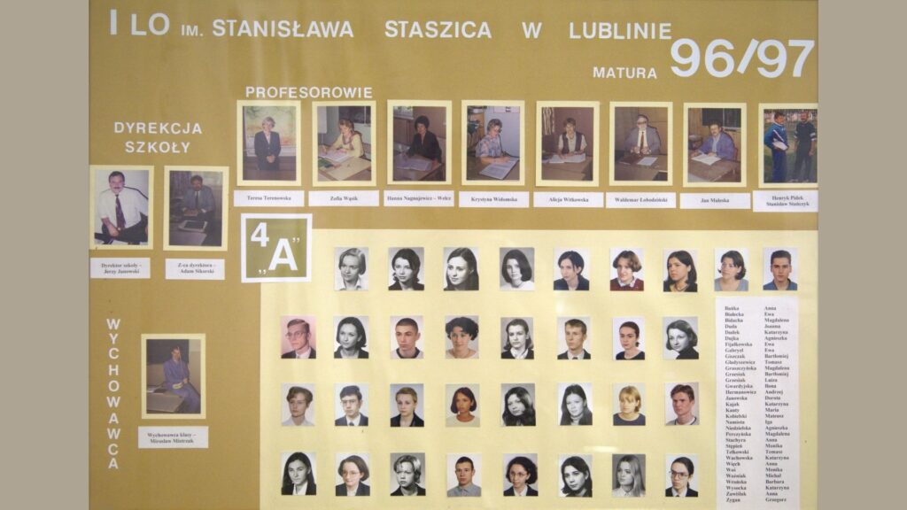 Plansza w kolorze złotym z białymi ramkami na zdjęcia. Na górze – portrety nauczycieli i dyrekcji, w kolorze. Centralnie umieszczony napis: „I LO im. Stanisława Staszica w Lublinie – matura 96/97 – klasa 4A”. Niżej – zdjęcia uczniów (kolorowe), w pięciu rzędach. Po prawej stronie lista imion i nazwisk uczniów wypisana w kolumnach.