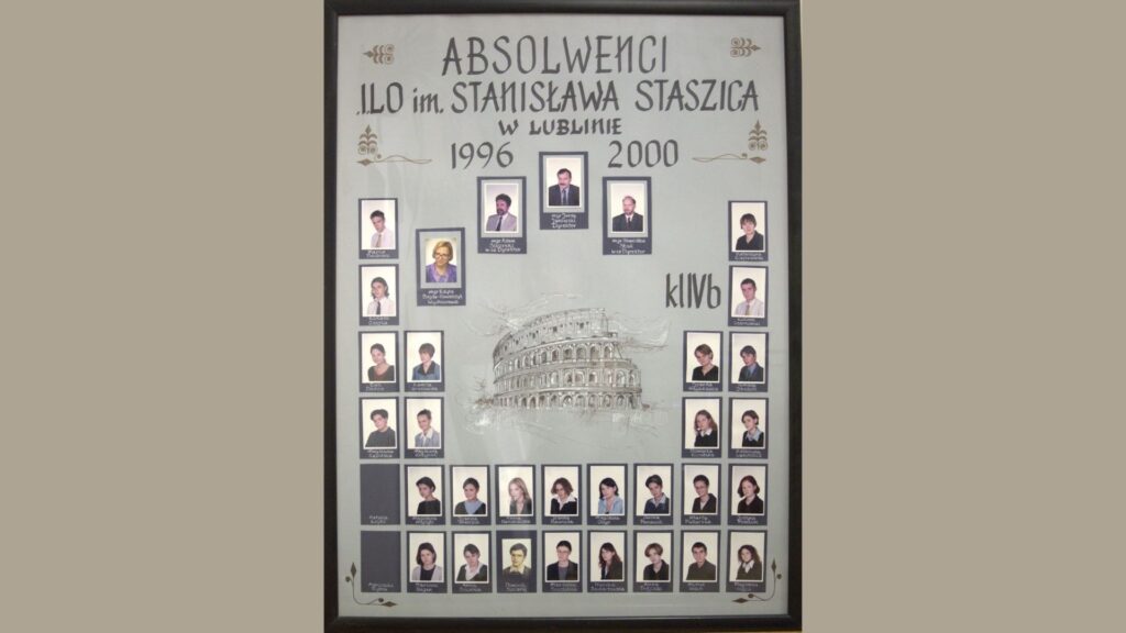 Plansza pionowa, jasnoszara, z delikatnymi ozdobami kwiatowymi. W centrum – rysunek Koloseum, z napisem „IVb”. Góra: zdjęcia dyrekcji i wychowawców – kolorowe, podpisane. Po bokach Koloseum – portrety uczniów rozmieszczone pionowo. Na dole – trzy rzędy zdjęć, łącznie ponad 35 osób. Wszystkie portrety w ramkach, podpisane imieniem i nazwiskiem.