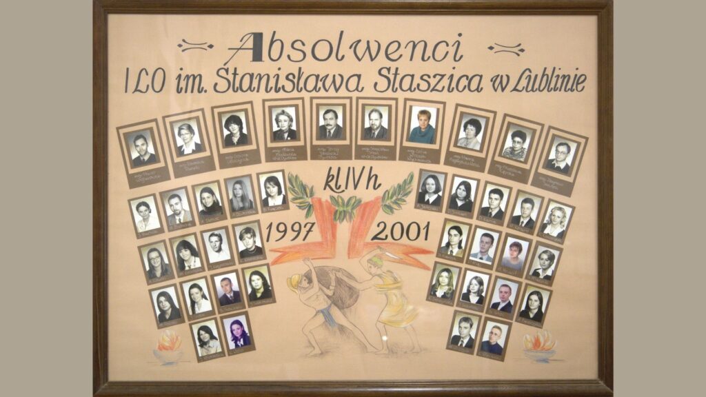 Plansza z beżowym tłem, portrety w brązowych ramkach. U góry – rząd zdjęć nauczycieli (czarno-białe), ułożone w linii łuku. W centrum – rysunek dwóch postaci mitologicznych: jedna popycha głaz, druga mu pomaga; nad nimi liściasty wieniec i napisy „1997” po lewej i „2001” po prawej. Zdjęcia uczniów ułożone wachlarzowo po bokach. Łącznie ok. 38 uczniów, wszystkie portrety czarno-białe, podpisane.