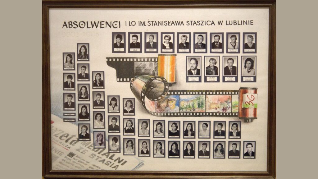 Plansza o unikalnym, filmowym charakterze. Tło przedstawia rozwiniętą kliszę fotograficzną. Na taśmie filmowej narysowane kolorowe scenki – szkoła, portret, miasto. Na górze – zdjęcia nauczycieli w dwóch rzędach. Pod kliszą – zdjęcia uczniów, czarno-białe w granatowych ramkach, podpisane. W lewym dolnym rogu widać fragment gazety z napisem: „Gazeta Wydziału ze Stasia”. Całość przypomina hołd dla wspomnień zapisanych jak film.