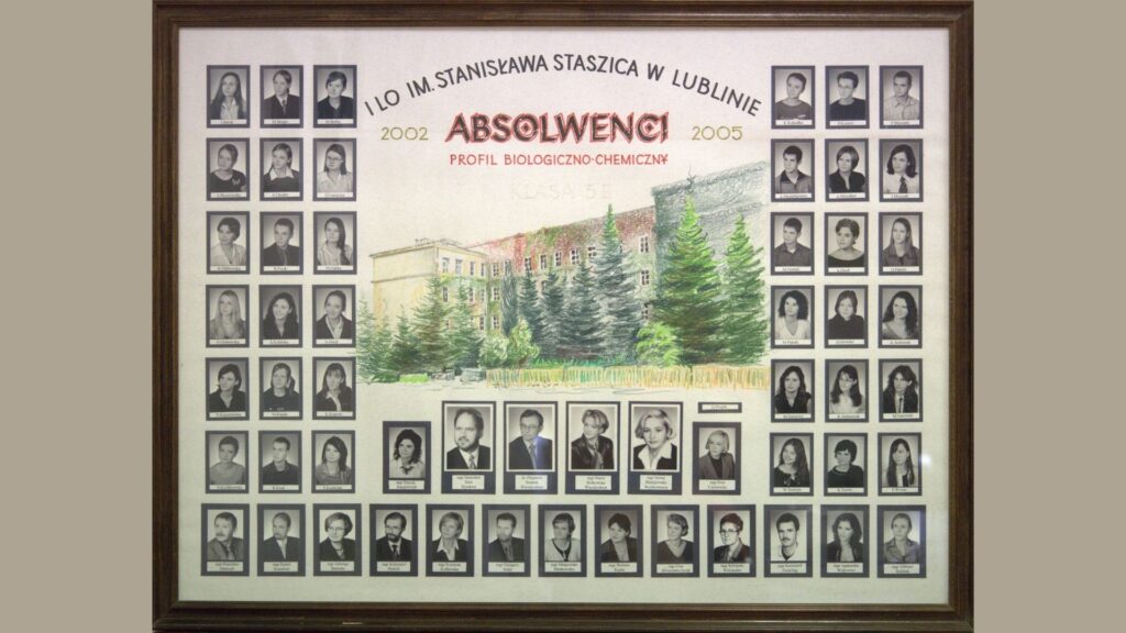 Tło jasne, z ręcznie rysowaną ilustracją budynku szkoły i świerków. Zdjęcia uczniów rozmieszczone są po lewej i prawej stronie rysunku w pionowych kolumnach. Portrety czarno-białe, w ciemnych ramkach z podpisami. Na górze napis łukiem: „I LO im. Stanisława Staszica w Lublinie – ABSOLWENCI” Z dopiskiem: „Profil biologiczno-chemiczny 2002–2005” Na dole – dwa rzędy zdjęć nauczycieli.