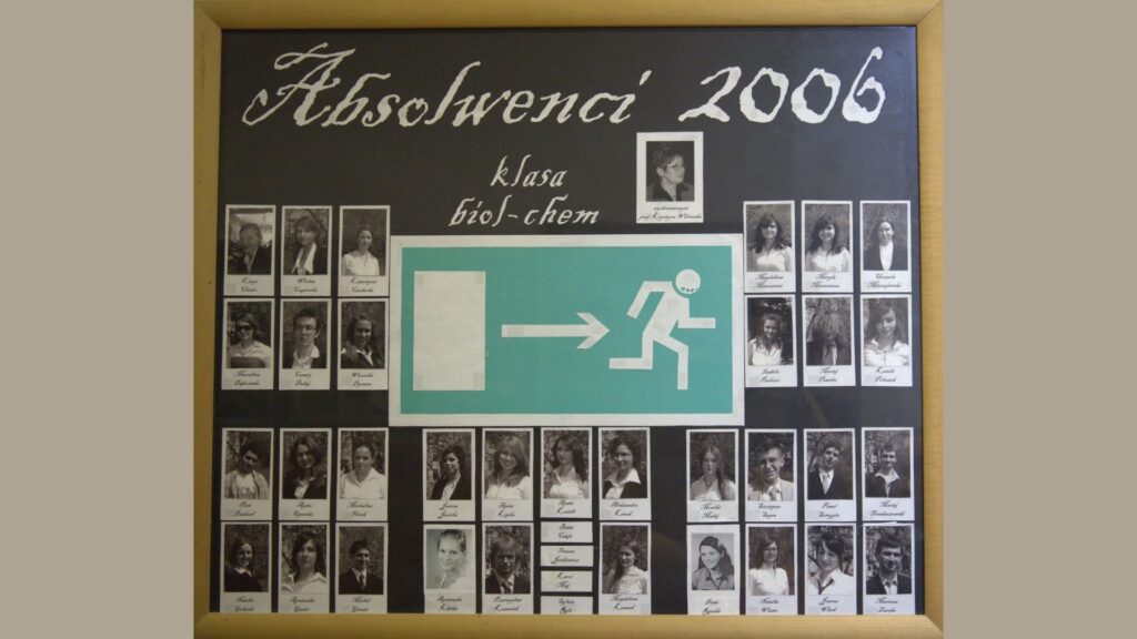 Plansza na czarnym tle z dużym znakiem zielonego wyjścia ewakuacyjnego w centralnej części – postać biegnąca w prawo. Nad znakiem – biały napis kredą: „Absolwenci 2006 – klasa bio-chem” Po bokach i pod spodem – czarno-białe zdjęcia uczniów, każde z podpisem. Na górze pośrodku – portret wychowawczyni. Plansza symboliczna: wyjście ze szkoły na nowe ścieżki życia.