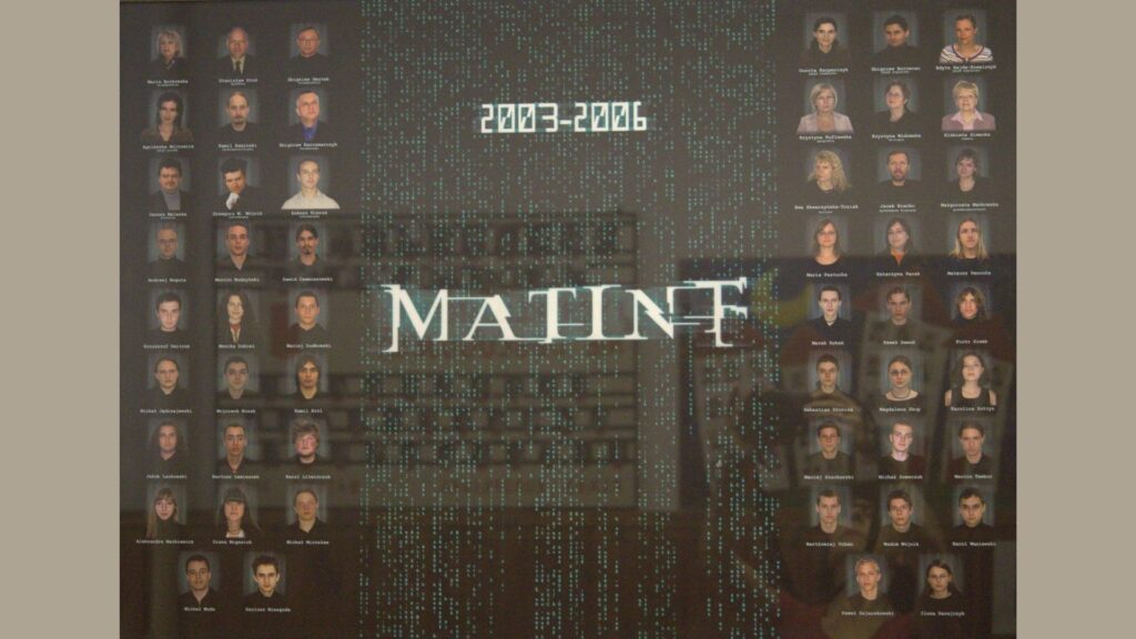 Czarne tło stylizowane na motyw z filmu „Matrix” – pionowe ciągi zielonych znaków spływających po ekranie. Na środku planszy – duży napis „MATINT” białą czcionką przypominającą font z Matrixa. Zdjęcia uczniów i nauczycieli rozmieszczone po lewej i prawej stronie – ułożone równo w kolumnach. Plansza ma mroczny, futurystyczny charakter – podkreślający profil klasy informatyczno-matematyczny.