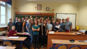 Zdjęcie klasowe w sali – uczniowie + tort (prawdopodobnie urodziny/świętowanie).