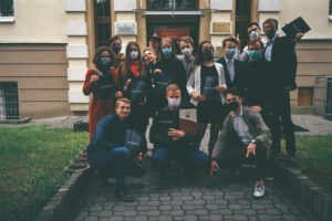 Podobne zdjęcie grupowe w tym samym miejscu – uczniowie pozują z dokumentami.