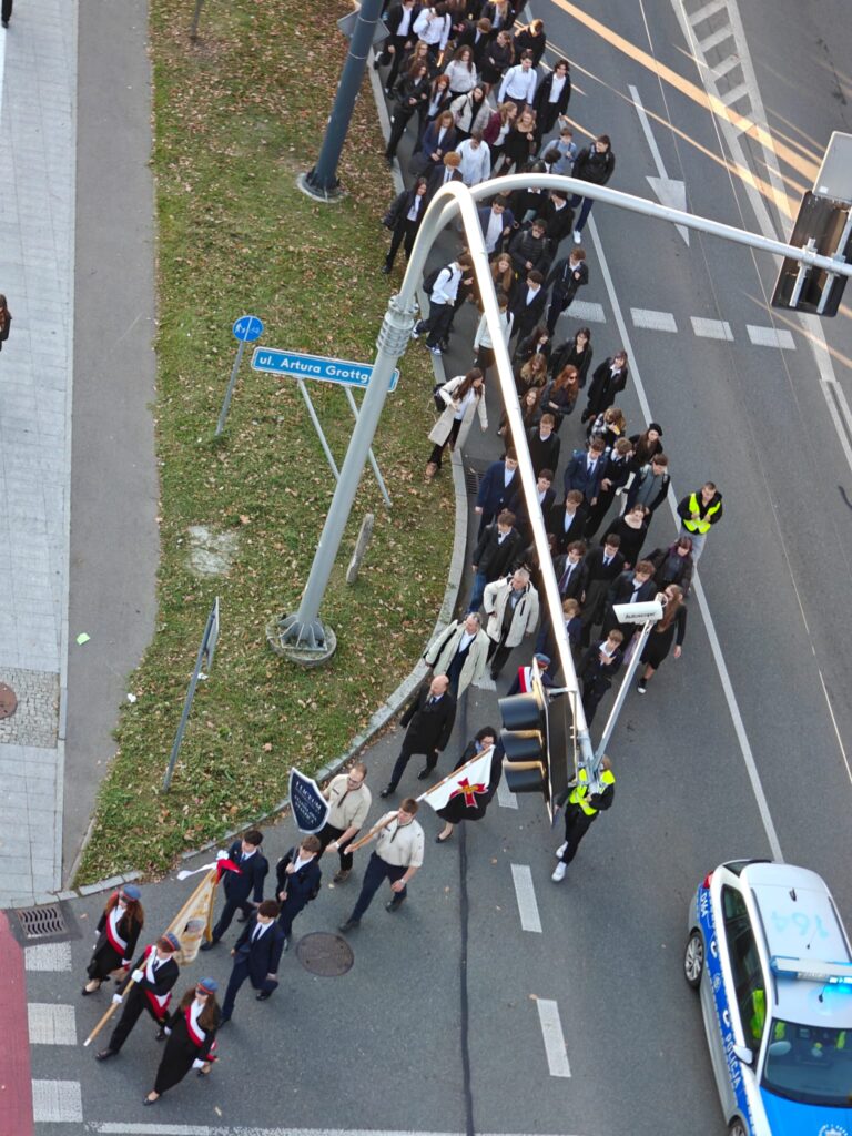 Widok z góry na uliczny pochód uczestników uroczystości.
