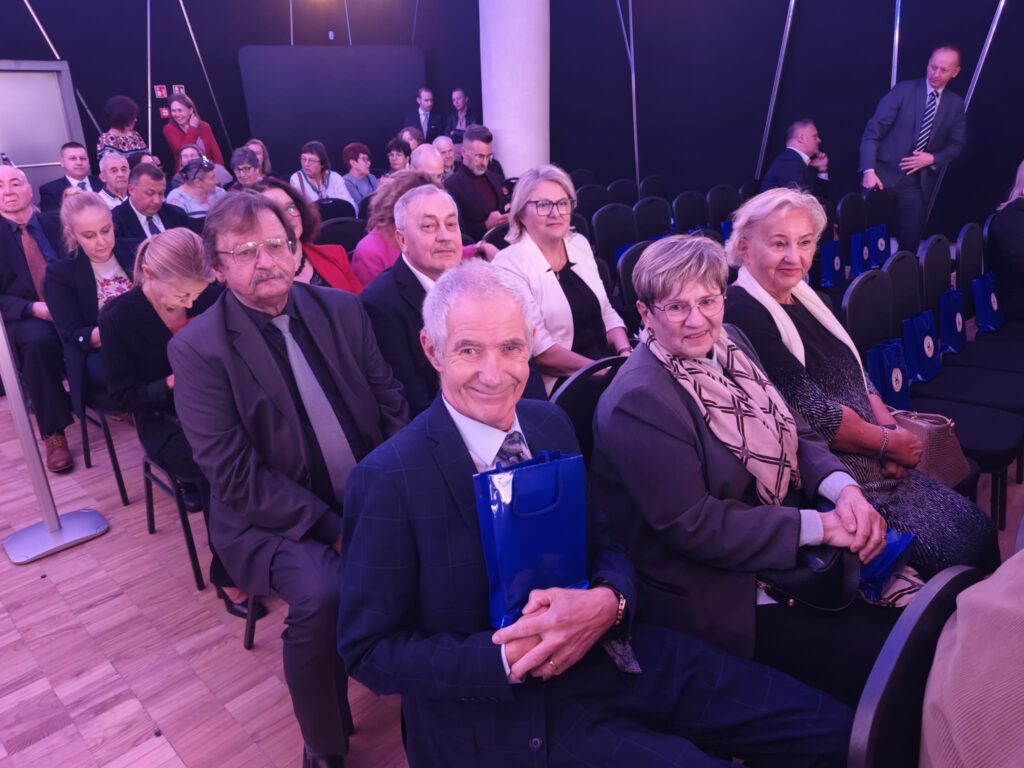 Zaproszeni goście siedzą w rzędach podczas uroczystego wydarzenia.